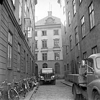 Gaffelgränd från Skeppsbron. I fonden Stockholms Sjömanshus, Gaffelgränd 1A. Cyklar parkerade längs husväggarna.