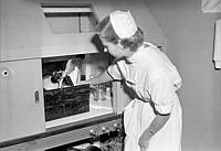 Radiumhemmet, Karolinska Sjukhuset. Operationssköterska Maj-Britt Lönnblad öppnar en ampull innehållande radioaktivt guld som ska prövas i bekämpningen av livmoderhalscancer.