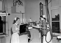 Centrallasarettet i Stocksund. ( Nu Danderyds Sjukhus). Röntgenavdelningen. Två sjuksköterskor röntgar en kvinna.