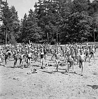 Flatenbadet. Barn springer ner för stranden vid sjön Flaten, mellan Drevviken och Ältasjön i Nacka, Badet invigdes 1934 och var Stockholms största fritidsbad.