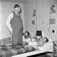 Norra Latins sommarhem på Björkö. Professor Gösta Forssell, besöker sommarhemmet på höstinspektion. Pojken t.h. Bo Boson Hellström ligger i sängen med feber.