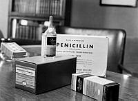 En ampull penicillin samt förpackningar med engelsk text uppställda på ett skrivbord. Penicillin prövades sedan ett par månader vid svenska sjukhus.