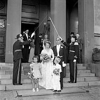 Skeppsholmskyrkan, exteriör. Bröllop mellan Carl-Erik Fröberg och Louise Wachtmeister. En flicka och en pojke är brudnäbbar. På ömse sidor om brudparet står två män i uniform med dragna blankvapen.