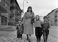 Sparbanksvägen. En kvinna med tre barn promenerar.