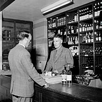 De sista kronflaskorna på systemet. En man köper Kron Brännvin och Absolut Rent i Systembolagets butik innan brännvinssorten Kron slutar säljas lagom till att motboken avskaffas hösten 1955.