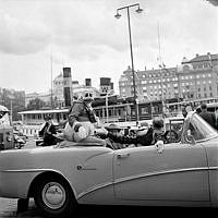 Nybrokajen. Kalle Anka och Långben i en öppen bil genom Stockholm.
