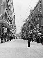 Snöskottning av tak på Drottninggatan.