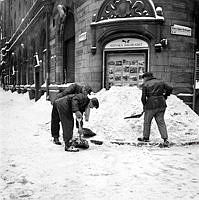 Snöröjning vid Svenska Dagbladets tidningshus i hörnet av Klara Södra Kyrkogata och Karduansmakargatan.