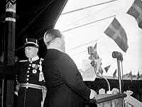 Stadion. Svenska flaggans dag firas. Jussi Björling sjunger från talarstolen.