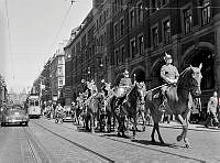 Kungliga Livgardesskvadronens (K1) musikkår till häst blåser in Nationaldagen. De rider söder ut på Vasagatan.