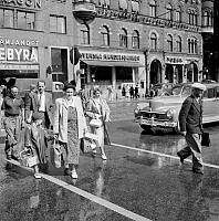 Vasagatan 12. Fotgängare går över gatan mellan Vasagatan 14 och Centralstationen, vid ett obevakat gul linje övergångsställe. De gula strecken hade nyligen målats på en ny sorts hållbarare hartsmassa.