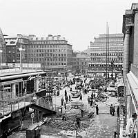 Sergelgatan, vy mot Hötorget. Gatuarbeten och torghandel två dagar innan invigningen av den första färdigbyggda hötorgsskrapan.