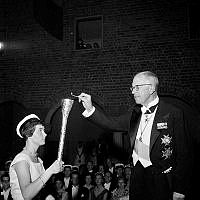 Hantverkargatan 1, Stadshuset. Invigning av Stockholms universitet. Kung Gustaf VI Adolf tänder den akademiska elden som bärs vidare av studenten Inga Broberg.