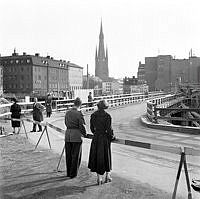 Mäster Samuelsgatan går på provisorisk bro, över tunnelbanebygget. Vy väster ut mot Klara kyrka, Klarabergsgatan och kv. Skansen (t.v.) och Sporren (t.h.).