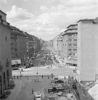 Korsningen Sveavägen och Kungsgatan. Vy Sveavägen norrut. T.h. rivning i kvarteret Järnplåten vid Oxtorgsgatan, förmodligen pga. tunnelbanebygget.