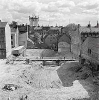 Jakobsbergsgatan på provisorisk bro. Bron går över ett schakt i Brunkebergsåsen där Sveavägen ska gå fram, några meter under den gamla gatunivån.