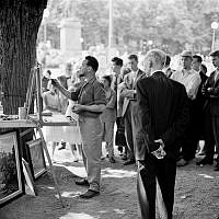 Kungsträdgården. En konstnär står och målar och folk har samlats för att titta på när han arbetar.