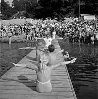 Simpromotion på Flatenbadet. Föräldrar och syskon tittar på.