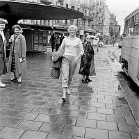 Stureplan vid Svampen, söderut. Kerstin Wintzell promenerar.