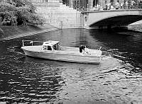 Norrström vid Riksbron och Norra Helgeandstrappan. Polis i en båt undersöker stöldgods som man funnit vid platsen.