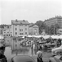 Medborgarplatsen mot nordost. Ett regnoväder har översvämmat torget under pågående torghandel.