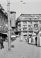 Tegelbacken. Till vänster Jakobsgatan 32, kv. Brandklipparen med f.d. Kronprinsens Stall, i fonden Tegelbacken 2, kv. Röda Bodarne. I förgrunden en högtalare på lyktstolpe.