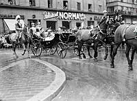 Sveavägen 23, kunglig kortege. Kung Gustaf V fyller 85 år och rider kortege genom staden. I vagnen sitter även kronprinsessan Louise och kronprinsen Gustaf Adolf. I bakgrunden t.h. Restaurant Norma.