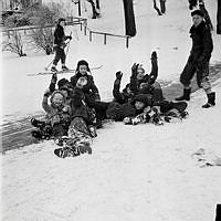 Barn leker i snön och åker skidor i Stockholms parker.