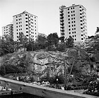 Danviksklippan. Nya punkthus byggs. Husen vetter mot Hammarbykanalen, där lastfartyg ses i förgrunden.