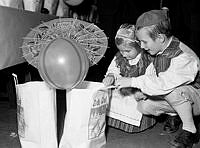 Hantverkargatan 1, Blå hallen i Stadshuset. Sällskapet jultomtarnes traditionella julfest för Stockholms barn. Syskonen Ulf och Meith Öberg tittar i julklappspåsen.