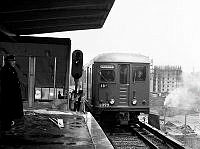 Tunnelbanetåg vid station Råcksta vid provkörning på linjen Kungsgatan/Hötorget-Vällingby fyra dagar innan invigningen som ägde rum 26 oktober 1952. I bakgrunden Ullångergatan 5 under byggnad.