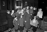 Centralstationen i Stockholm. Nio tyska och österrikiska ensamstående barn under 6 år kom på torsdagskvällen den 6 mars 1952 till Stockholm. De omhändertogs av Rädda Barnen för att sedan adopteras av svenska familjer. I bildens mitt den tyska vårdarinnan Elli Schulz