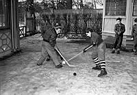 Engelska skolan, skolgården. Elever leker med ishockeyklubbor och puck.