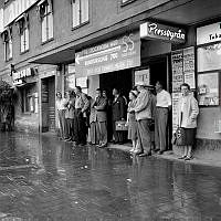 Tegelbacken. Stockholmare söker skydd för regn utanför vänthall.