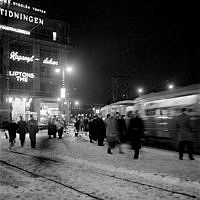 Folkliv på Tegelbacken. T. v. Neonskyltar på Centralpalatset.