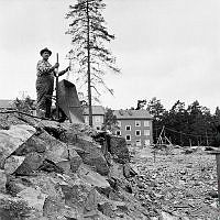 Blackeberg. En man med en skottkärra vid byggområde.