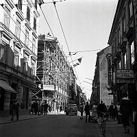 Drottninggatan söderut vid korsningen med Klarabergsgatan. Rivningshuset Drottninggatan 46 med byggnadsställningar.