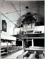 Interiör av Finska kyrkan från altaret mot bänkraderna och orgelläktaren.