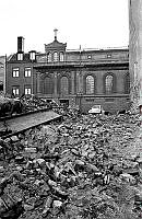 Norra Smedjegatan 17, 19 och 21 är rivna. I fonden bakom rivningsmassorna syns Sankta Eugeniakyrkan.