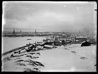 Vy österut över Ludvigsbergs fabriksområde från Skinnarviksberget. I fonden Riddarholmen och Gamla Stan