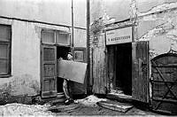 Norra Smedjegatan 5. Man som bär en dörr på gården.