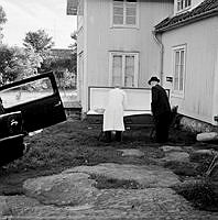 Avlidna Emilia Lindgren ligger i kista utanför sitt hus i Rävsnäs. Svepning iordningställs av begravningsentreprenör.