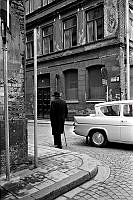 En herre med spatserkäpp och klädd i kubb vid Herkulesgatan 8 i hörnet av Norra Smedjegatan.