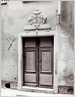 Tvådelad träport med en skulptural ornamentik i heraldisk stil