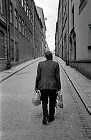 Man på väg uppför Norra Smedjegatan norrut mot Hamngatan.