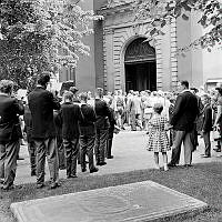 Musikkår och besökare utanför Maria kyrkas västra portal. I förgrunden en gravhäll.
