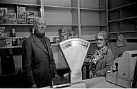 Norra Smedjegatan 5. Maja Erikssons mjölkbutik. Troligen är butiken redan stängd. Maja Eriksson och troligen hennes man står finklädda framför de nästan helt tomma hyllorna.